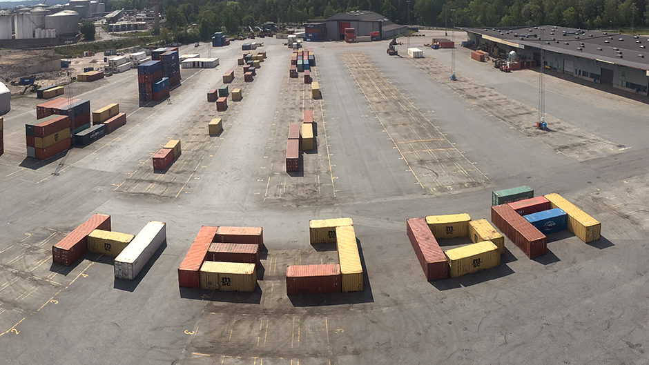 Ett antal containrar i Frihamnen som tillsammans formar orden Hej då.