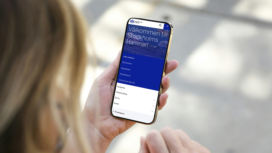 En person tittar på Stockholms Hamnars nya webbplats i sin mobil.