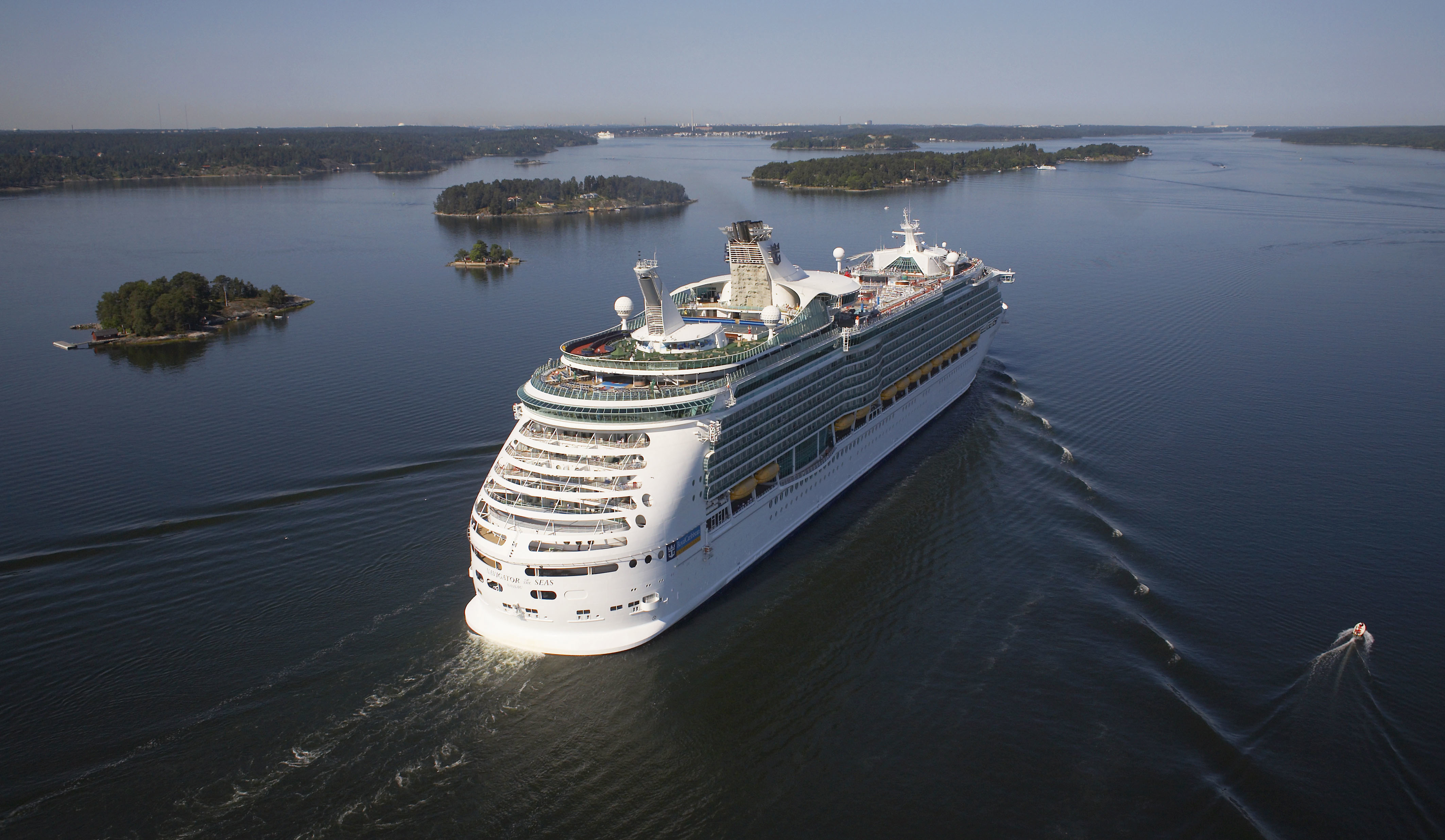 Ett stort kryssningsfartyg som seglar genom skärgården.