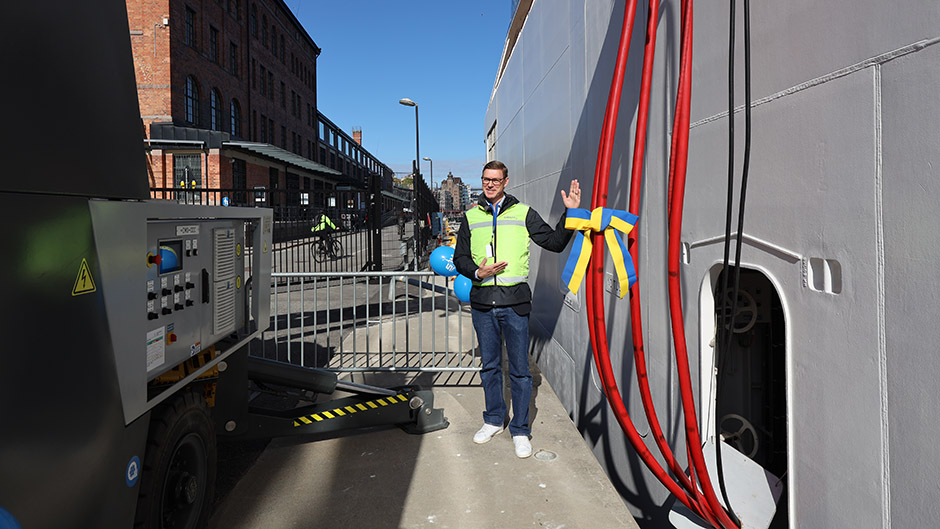 Glad hamnanställd framför kryssningsfartyg.