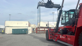 Containertruck plockar upp en husmodul från kajen i Frihamnen.