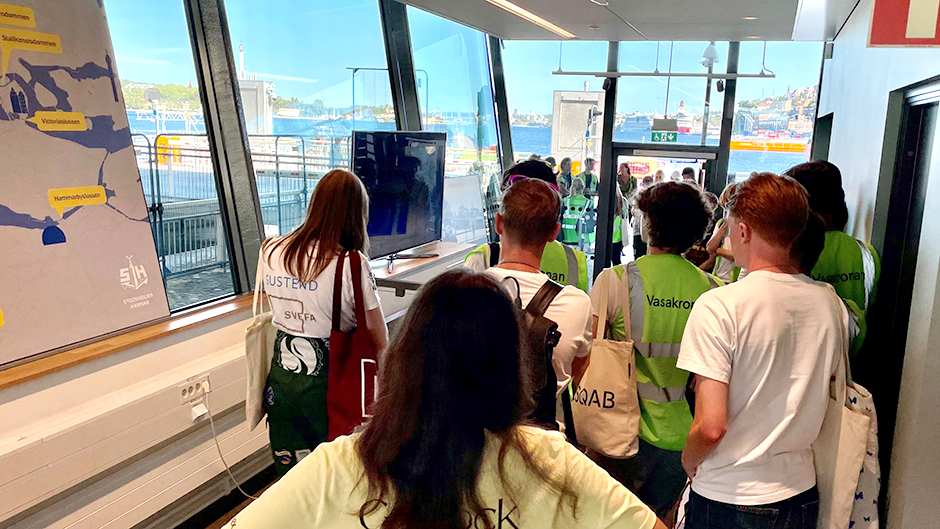 Ryggvy av studenter som tittar på en film inne i slusskontoret.