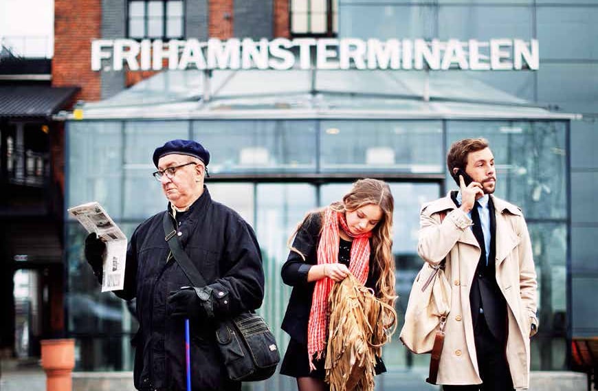 Tre olika typer av passagerare står utanför Frihamnsterminalen.