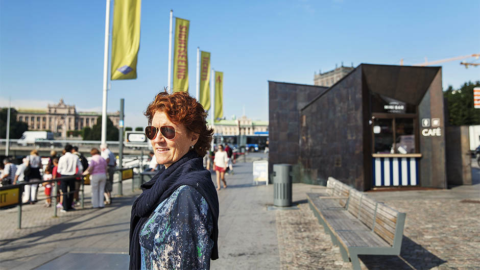Irene Lindbäck framför en av de nya fastigheterna på nyrenoverade Strömkajen