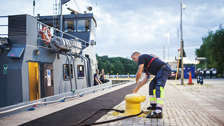 Mats Collin hjälper till att förtöja ett fartyg i Hammarbyslussen