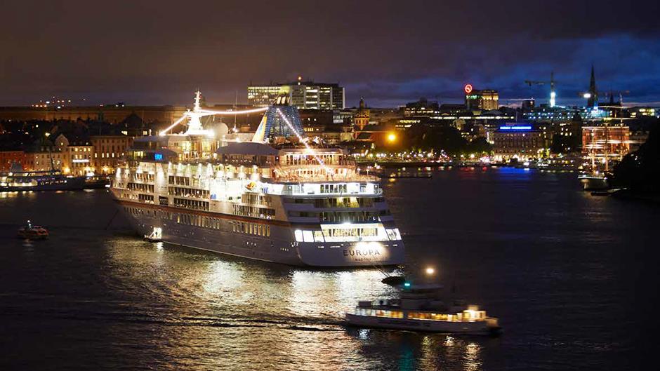 Kryssningsfartyget Europa i vackert kvällsljus, förtöjd på Strömmen med Skeppsbron i bakgrunden.