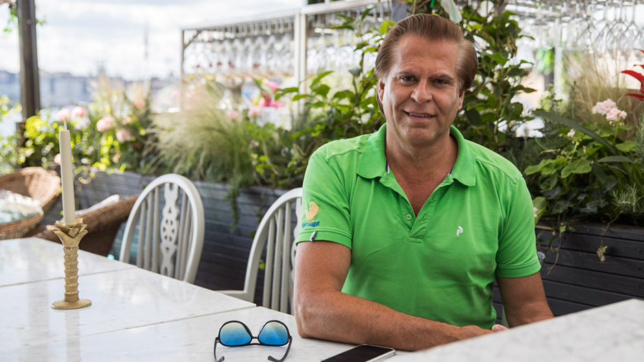 Christos Neo vid ett bord i Glashuset