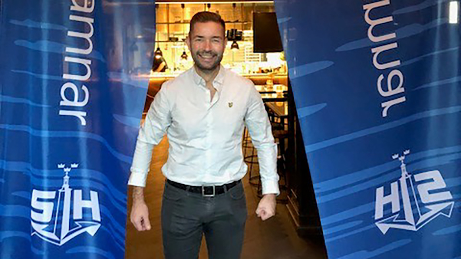 Glad kille framför Stockholms Hamnar-flaggor