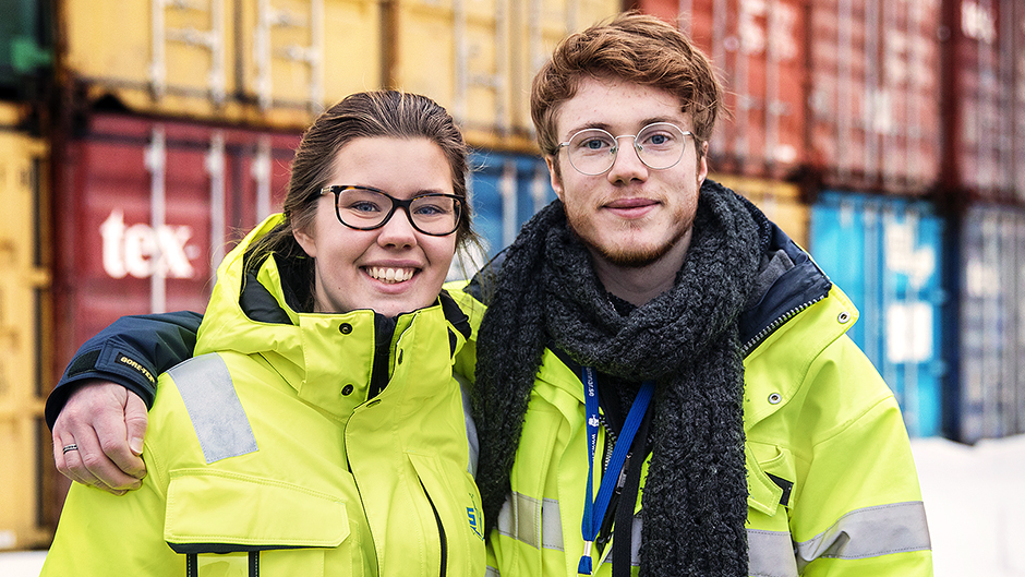 Sara Ferndahl och Anders Gyllensvärd framför en stapel containrar