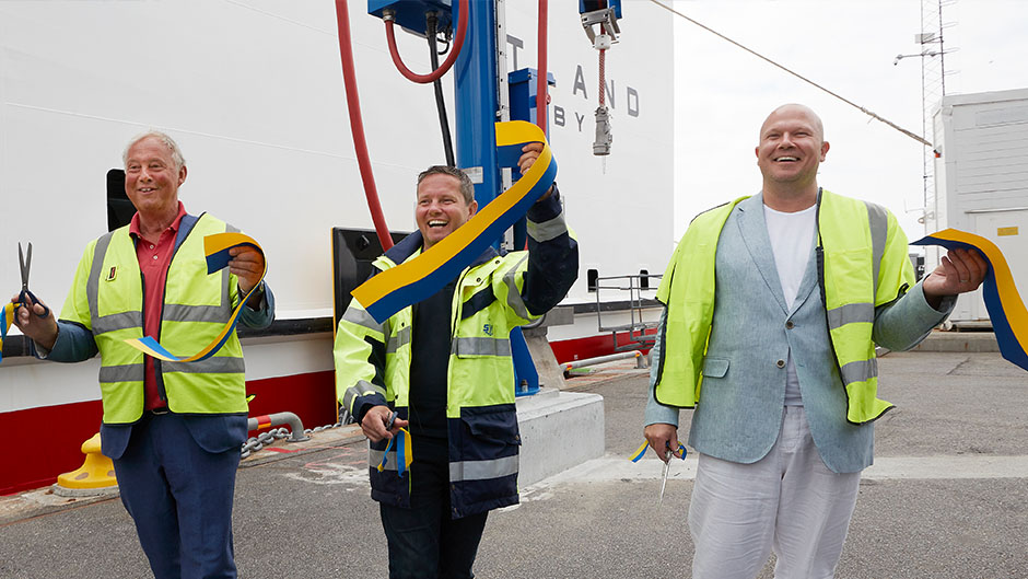 Tre män klipper band för att inviga elanslutningen i Nynäshamns hamn