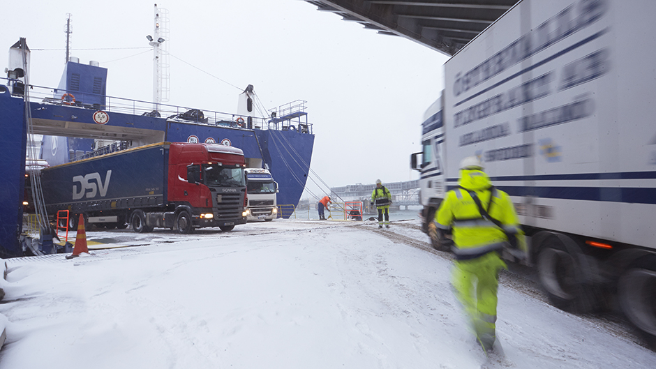 Lastbil rullar av fartyg i ett snöigt Kapellskärs hamn