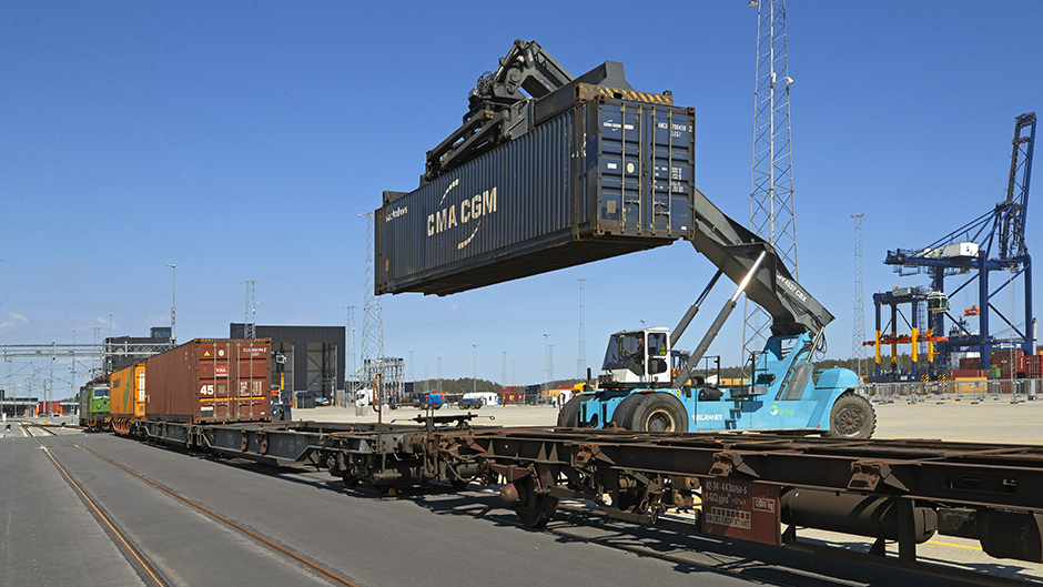 Containertruck lastar på container på tåg