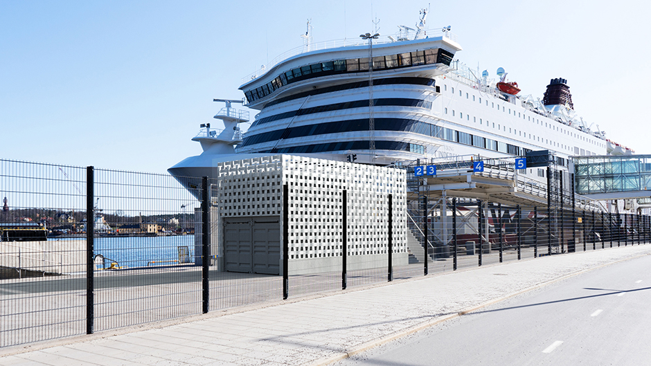 En av elanläggningsbyggnaderna framför ett kryssningsfartyg