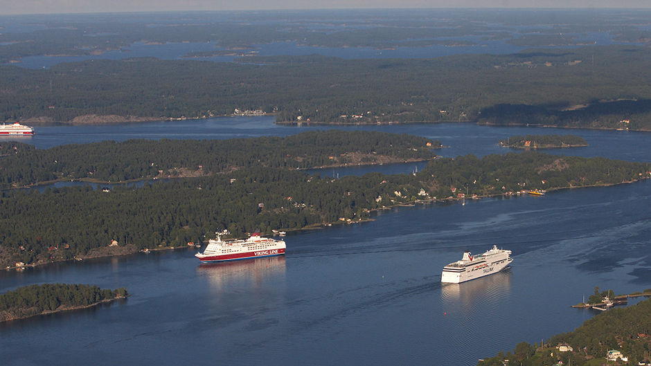 Flygbild över Viking Line-fartyg och Tallink Silja-fartyg som möts i farleden i skärgården