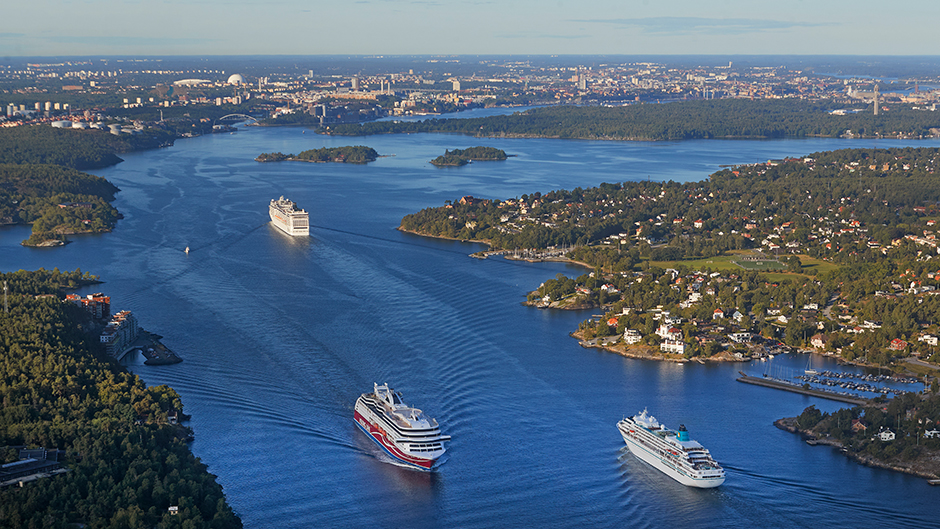Flygbild av inloppet över Stockholm med tre stora fartyg i fonden