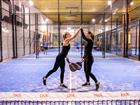 Två tjejer gör highfive på en padelbana