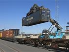 Containertruck lastar på container på tåg