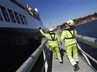 Två hamnarbetare i Kapellskärs hamn går längs med ett fartyg