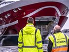 Två män i varselkläder framför Viking Glorys öppna bogport