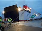 Två hamnarbetare håller på och förtöjer Stena Flavia i Stockholm Norvik Hamn på kvällen