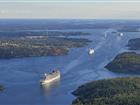 Flygbild över farleden in till Stockholm med ett pärlband av fartyg på väg in och ut