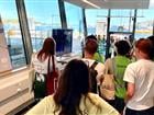 Studenter står inne i slusskontoret och tittar på en film