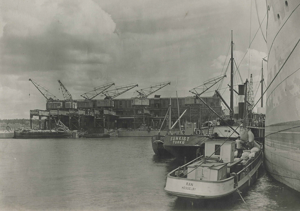 Frihamnen 1921: Johnson - båt under lossning vid Magasin 1, lossning utsides till Finlandsbåt. I bakgrunden Magasin 2.