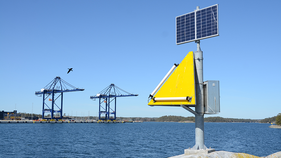 Sjömärke i förgrunden och två containerkranar i bakgrunden